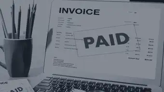 Laptop with red paid invoice stamp